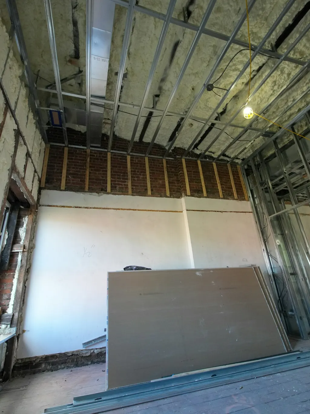 Interior room with drywall removed to expose framing during demolition